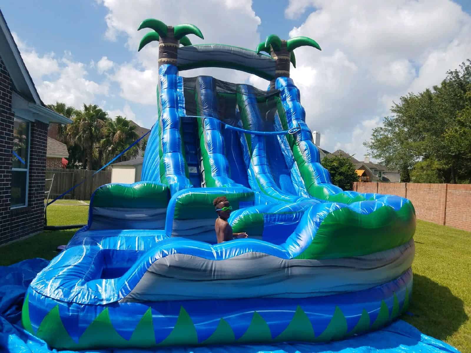 Tropical Inflatable Water Slide Rental Child standing inside a tropical palm tree inflatable water slide