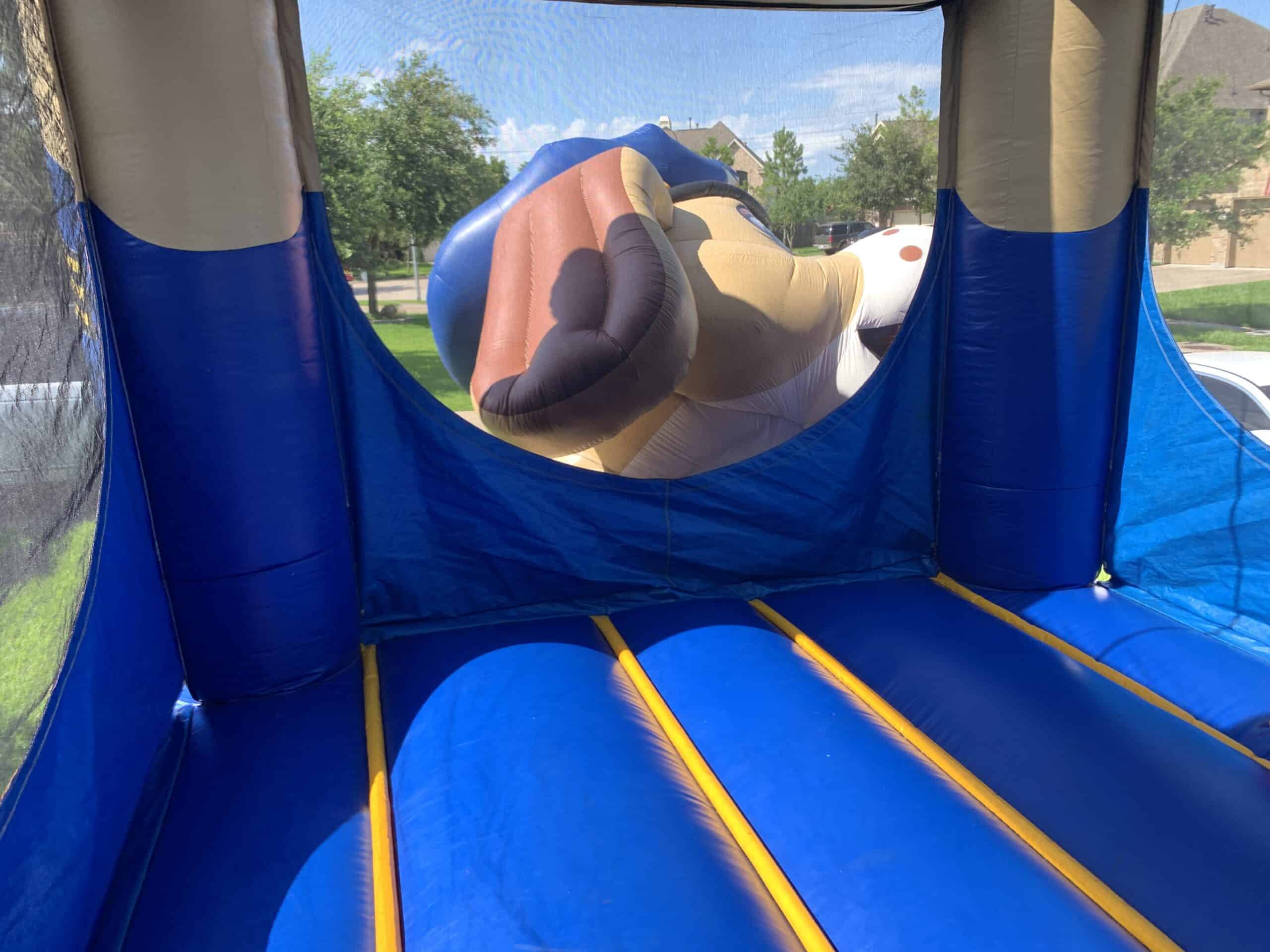 Interior view of a blue bounce house with yellow floor stripes