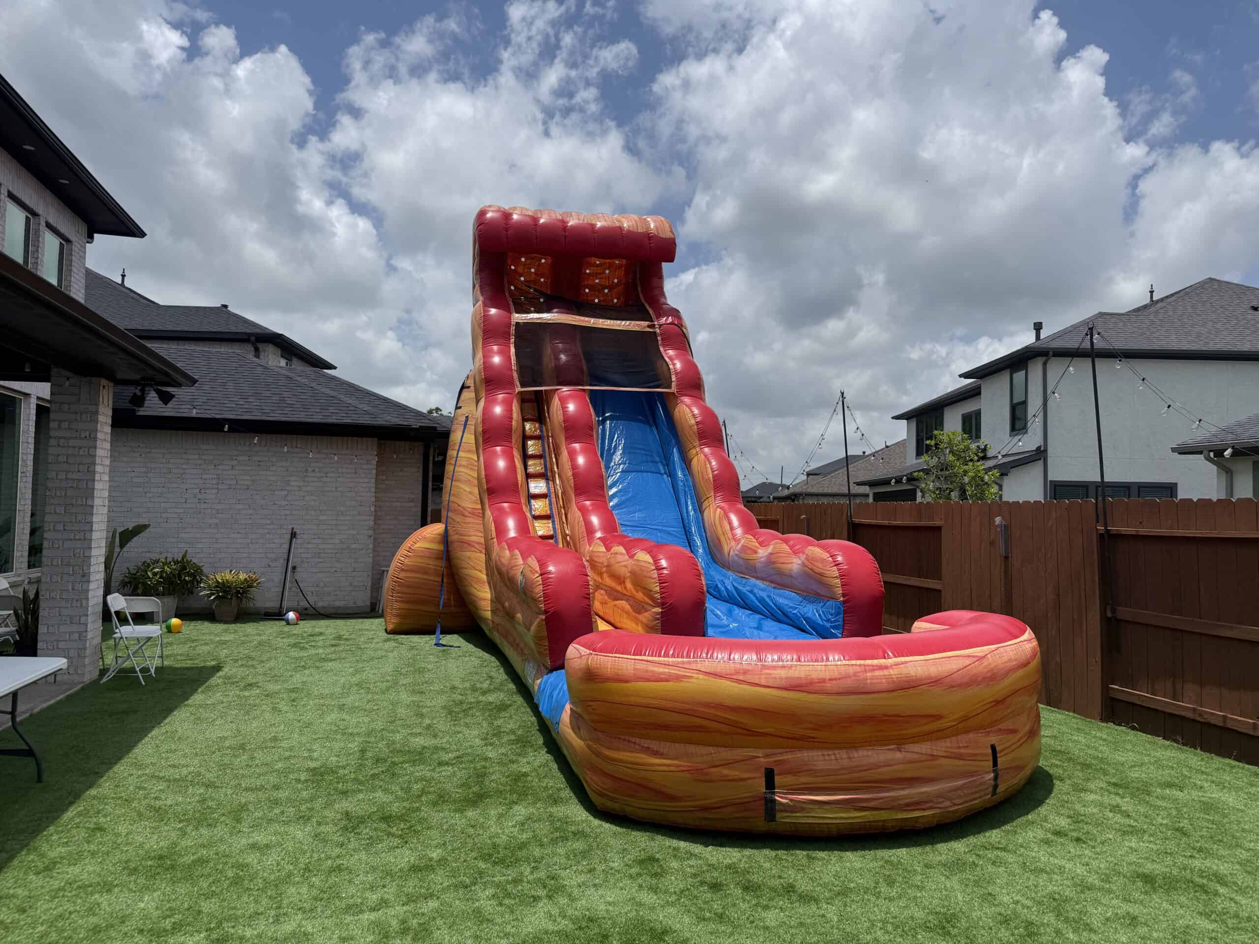 Mega Red Inflatable Water Slide Tall red and yellow inflatable water slide in a backyard