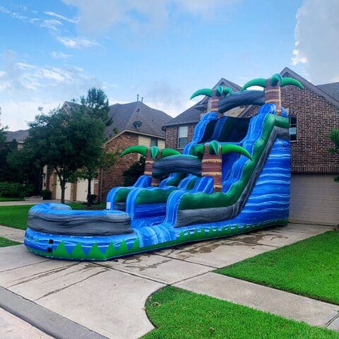 Colorful inflatable water slide with palm trees for outdoor fun.