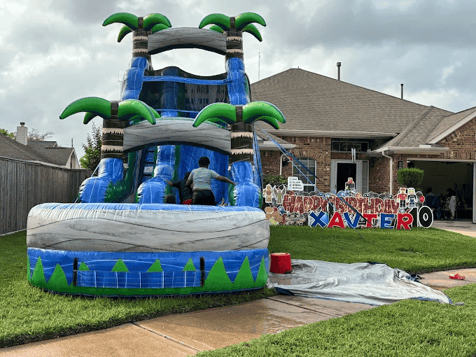 Colorful inflatable water slide with palm trees for kids.