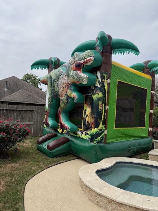 Dinosaur-themed bounce house with T-Rex design and jungle scenery.
