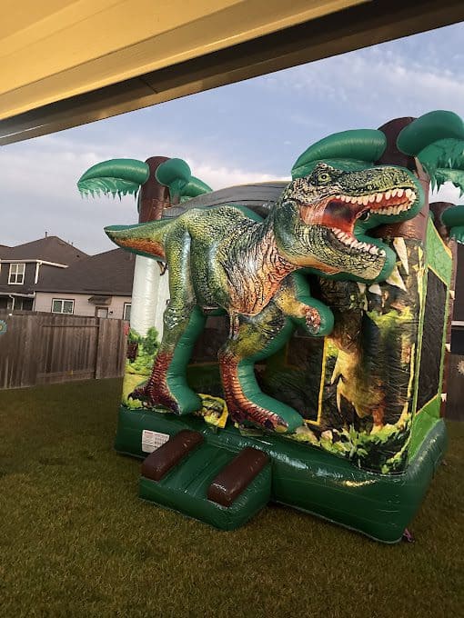 Colorful T-Rex bounce house with jungle theme for kids' parties.